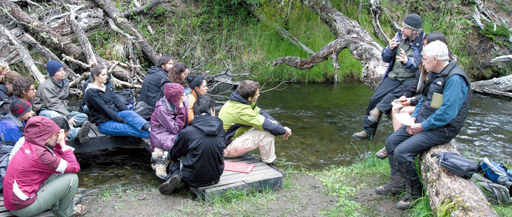 Instructors speaking to students by a creek